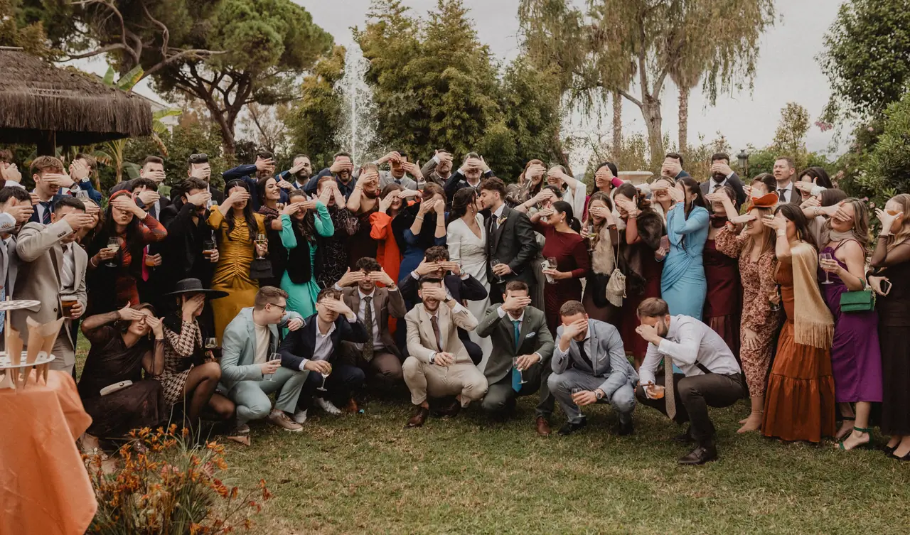 Invitados tapándose los ojos mientras los novios se besan